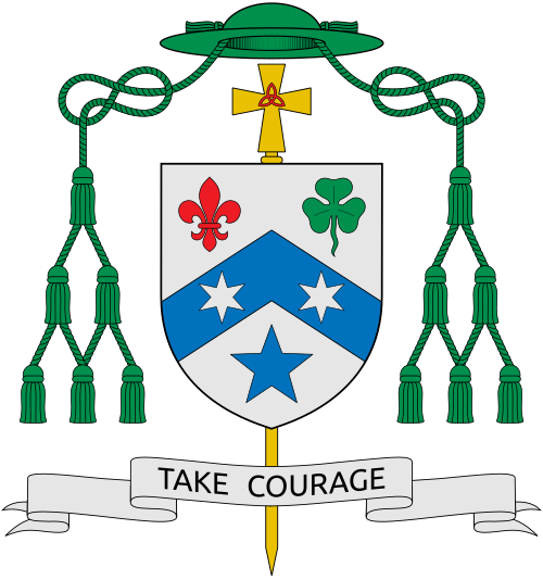 Coat of arms of the bishop John Gregory Kelly, Auxiliary Bishop of Dallas, Texas. Blazon: Argent, upon a chevron Azure two estoiles of the first; between to chief dexter a fleur-de-lis Gules and to chief sinister a trefoil Vert and to base a star, all of the second. Motto: "TAKE COURAGE". Reference: www.cathdal.org