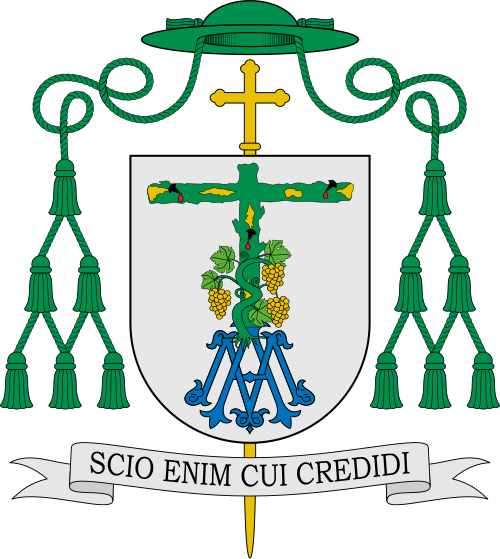 Escudo de Joseba Segura. Blasonamiento: Trae: En campo de plata, Santa Vera Cruz arbórea de sinople ecotada y descortezada en oro, adornada de los tres santos Clavos de sable en las puntas, goteados de gules. Acompañada al pie de cepa de vid en su esmalte natural con cuatro pámpanos y tres racimos de oro.En punta, Dulce Nombre de María adornada de lises en las tres puntas de la A, de azur.Acola cruz episcopal trebolada de oro.Al timbre, de sinople, capelo episcopal.La divisa prelaticia reza: SCI